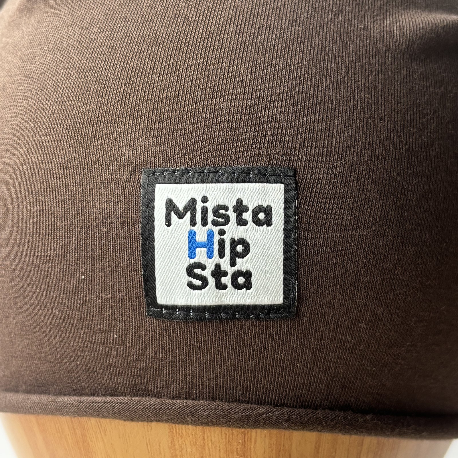 Naszywka MistaHipsta z niebieskim H na brązowej czapce beanie