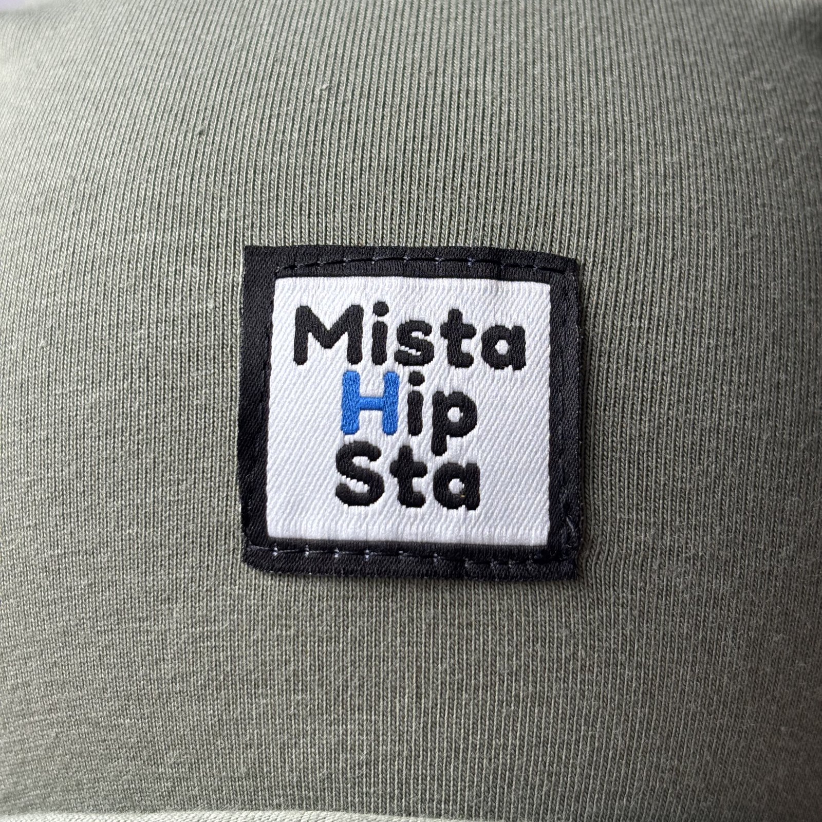Naszywka MistaHipsta z niebieskim H na oliwkowej czapce beanie
